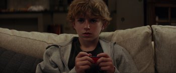 Movie still from “Secret Headquarters” (2022), directed by Henry Joost – A young boy holding a remote control in his hands; Close Up shot, High angle