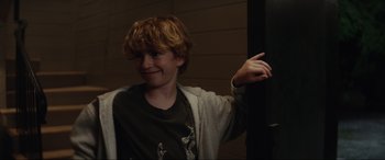 Movie still from “Secret Headquarters” (2022), directed by Henry Joost – A young boy is smiling and pointing to the side; Close Up shot, Over the shoulder angle