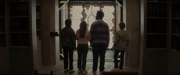 Movie still from “Secret Headquarters” (2022), directed by Henry Joost – A group of people standing in front of an open door; Medium shot, Low angle