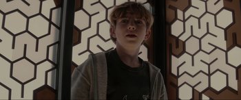 Movie still from “Secret Headquarters” (2022), directed by Henry Joost – A young boy standing in front of a window; Close Up shot, Low angle