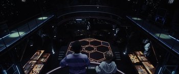 Movie still from “Secret Headquarters” (2022), directed by Henry Joost – Two people sitting in front of an illuminated floor; Wide shot, High angle