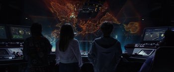 Movie still from “Secret Headquarters” (2022), directed by Henry Joost – Two people standing in front of a projection screen; Medium shot, High angle