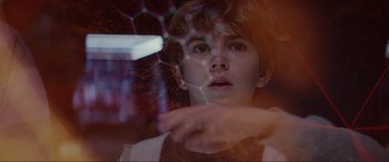 Movie still from “Secret Headquarters” (2022), directed by Henry Joost – A young boy looking at the camera through a glass; Close Up shot, Over the shoulder angle
