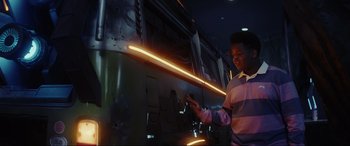 Movie still from “Secret Headquarters” (2022), directed by Henry Joost – A man standing in front of a train at night; Medium shot, Low angle