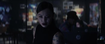 Movie still from “Secret Headquarters” (2022), directed by Henry Joost – A woman in a black dress with tattoos on her arms; Close Up shot, Over the shoulder angle
