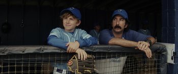 Movie still from “Secret Headquarters” (2022), directed by Henry Joost – Two baseball players sitting in a cage with a baseball glove on top; Medium shot, Over the shoulder angle
