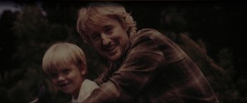 Movie still from “Secret Headquarters” (2022), directed by Henry Joost – A man and a boy smiling for the camera; Close Up shot, High angle