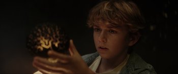 Movie still from “Secret Headquarters” (2022), directed by Henry Joost – A young boy holding a chocolate doughnut in his hands; Close Up shot, Low angle