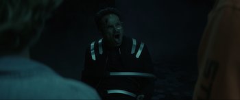 Movie still from “Secret Headquarters” (2022), directed by Henry Joost – A man in a black jacket and glasses is yawning; Medium shot, Low angle