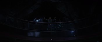 Movie still from “Secret Headquarters” (2022), directed by Henry Joost – A man standing in a dark room with his arms outstreched; Wide shot, Low angle