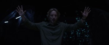 Movie still from “Secret Headquarters” (2022), directed by Henry Joost – A man standing in the dark with his arms outstreched; Medium shot, Low angle