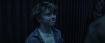 Movie still from “Secret Headquarters” (2022), directed by Henry Joost – A young man in a white t - shirt is looking at the camera; Close Up shot, Over the shoulder angle