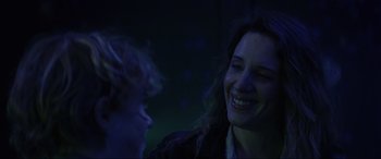 Movie still from “Secret Headquarters” (2022), directed by Henry Joost – A woman and a man smiling at each other in the dark; Close Up shot, Over the shoulder angle