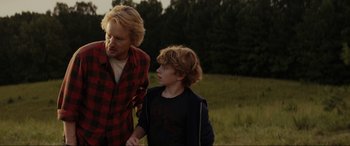 Movie still from “Secret Headquarters” (2022), directed by Henry Joost – A man and a boy are walking in a field; Medium shot, Over the shoulder angle