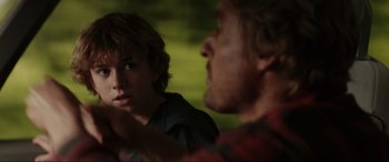 Movie still from “Secret Headquarters” (2022), directed by Henry Joost – A man and a boy looking at one another in the mirror; Close Up shot, Over the shoulder angle