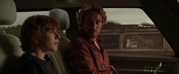 Movie still from “Secret Headquarters” (2022), directed by Henry Joost – A man sitting in the back seat of a car; Medium shot, Over the shoulder angle