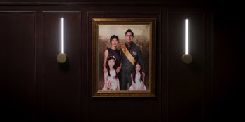 Movie still from “Secret Society of Second Born Royals” (2020), directed by Anna Mastro – A portrait of a man and his family hanging on the wall; Medium shot, High angle