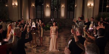 Movie still from “Secret Society of Second Born Royals” (2020), directed by Anna Mastro – A group of people standing in a room holding wine glasses; Wide shot, Low angle
