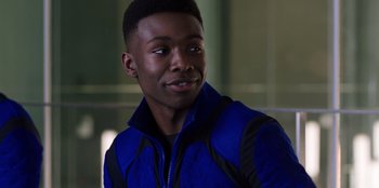 Movie still from “Secret Society of Second Born Royals” (2020), directed by Anna Mastro – A young man in a blue and black jacket looks to his left; Close Up shot, Over the shoulder angle