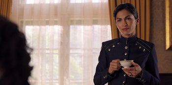 Movie still from “Secret Society of Second Born Royals” (2020), directed by Anna Mastro – A woman holding a cup in her hands; Medium shot, Low angle