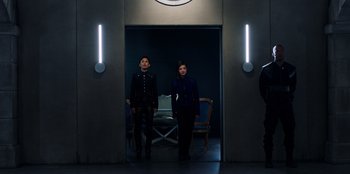 Movie still from “Secret Society of Second Born Royals” (2020), directed by Anna Mastro – A man and a woman standing next to each other in front of a door; Wide shot, Low angle