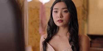 Movie still from “Secret Society of Second Born Royals” (2020), directed by Anna Mastro – A woman with long black hair wearing a pink dress; Close Up shot, Over the shoulder angle