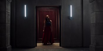 Movie still from “Secret Society of Second Born Royals” (2020), directed by Anna Mastro – A woman standing in front of an open door; Wide shot, Low angle