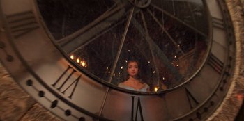 Movie still from “Secret Society of Second Born Royals” (2020), directed by Anna Mastro – A woman standing in front of a large clock; Medium shot, Low angle