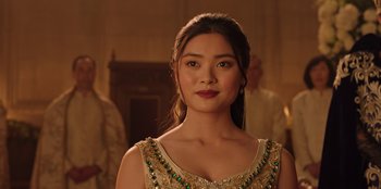 Movie still from “Secret Society of Second Born Royals” (2020), directed by Anna Mastro – A beautiful young lady wearing a gold dress; Close Up shot, Over the shoulder angle
