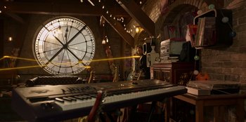 Movie still from “Secret Society of Second Born Royals” (2020), directed by Anna Mastro – A room with a large clock and a large keyboard; Extreme Wide shot, High angle