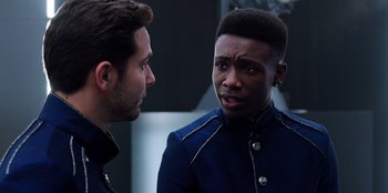 Movie still from “Secret Society of Second Born Royals” (2020), directed by Anna Mastro – Two men talking to each other in front of a building; Close Up shot, Over the shoulder angle