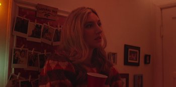 Movie still from “See You Next Christmas” (2021), directed by Christine Weatherup – A woman with long blonde hair is holding a cup; Close Up shot, Over the shoulder angle