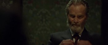 Movie still from “Blackthorn” (2011), directed by Mateo Gil – An older man in a gray suit and a red neck tie; Close Up shot, Low angle