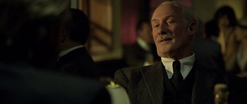 Movie still from “Blackthorn” (2011), directed by Mateo Gil – An older man in a suit and tie; Close Up shot, Over the shoulder angle