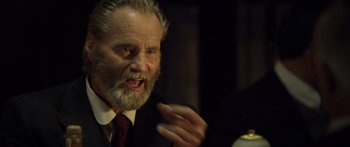 Movie still from “Blackthorn” (2011), directed by Mateo Gil – An old man with a beard and a mustache talking; Close Up shot, Over the shoulder angle