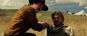 Movie still from “Blackthorn” (2011), directed by Mateo Gil – A man in a cowboy hat and a man in an old west outfit cutting another man's hair; Medium shot, Over the shoulder angle