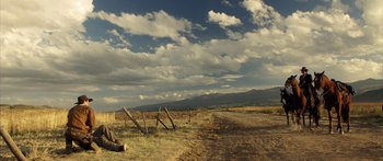Movie still from “Blackthorn” (2011), directed by Mateo Gil – A dirt road that has a fence on the side of the road; Extreme Wide shot, Low angle
