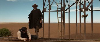 Movie still from “Blackthorn” (2011), directed by Mateo Gil – A man and a woman standing next to each other on a platform; Wide shot, Low angle
