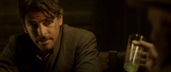 Movie still from “Blackthorn” (2011), directed by Mateo Gil – A person wearing a suit and glasses; Close Up shot, Over the shoulder angle