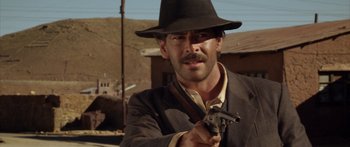 Movie still from “Blackthorn” (2011), directed by Mateo Gil – A man with a hat holding a gun in his hand; Close Up shot, Over the shoulder angle