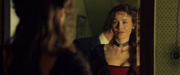 Movie still from “Blackthorn” (2011), directed by Mateo Gil – A woman in a red dress looking in the mirror; Close Up shot, Over the shoulder angle