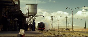 Movie still from “Blackthorn” (2011), directed by Mateo Gil – A train on a track near a building; Extreme Wide shot, Low angle