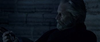 Movie still from “Blackthorn” (2011), directed by Mateo Gil – An old man with a beard is sitting in a dark room; Close Up shot, Over the shoulder angle