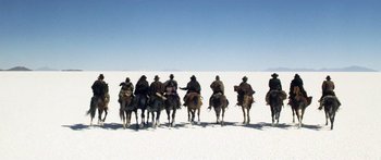 Movie still from “Blackthorn” (2011), directed by Mateo Gil – A group of people riding horses across a snow covered ground; Extreme Wide shot, Low angle