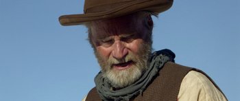 Movie still from “Blackthorn” (2011), directed by Mateo Gil – An old man with a beard wearing a cowboy hat; Close Up shot, Low angle