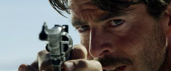 Movie still from “Blackthorn” (2011), directed by Mateo Gil – A person holding a gun; Extreme Close Up shot, Over the shoulder angle
