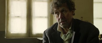 Movie still from “Blackthorn” (2011), directed by Mateo Gil – A person wearing a suit and tie; Close Up shot, Over the shoulder angle