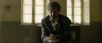 Movie still from “Blackthorn” (2011), directed by Mateo Gil – A man sitting in a chair with his hands crossed; Medium shot, Over the shoulder angle