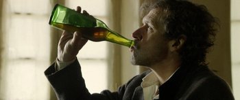 Movie still from “Blackthorn” (2011), directed by Mateo Gil – A man is drinking a beer from a bottle; Close Up shot, Low angle
