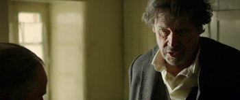 Movie still from “Blackthorn” (2011), directed by Mateo Gil – An older man in a suit and tie; Close Up shot, Over the shoulder angle